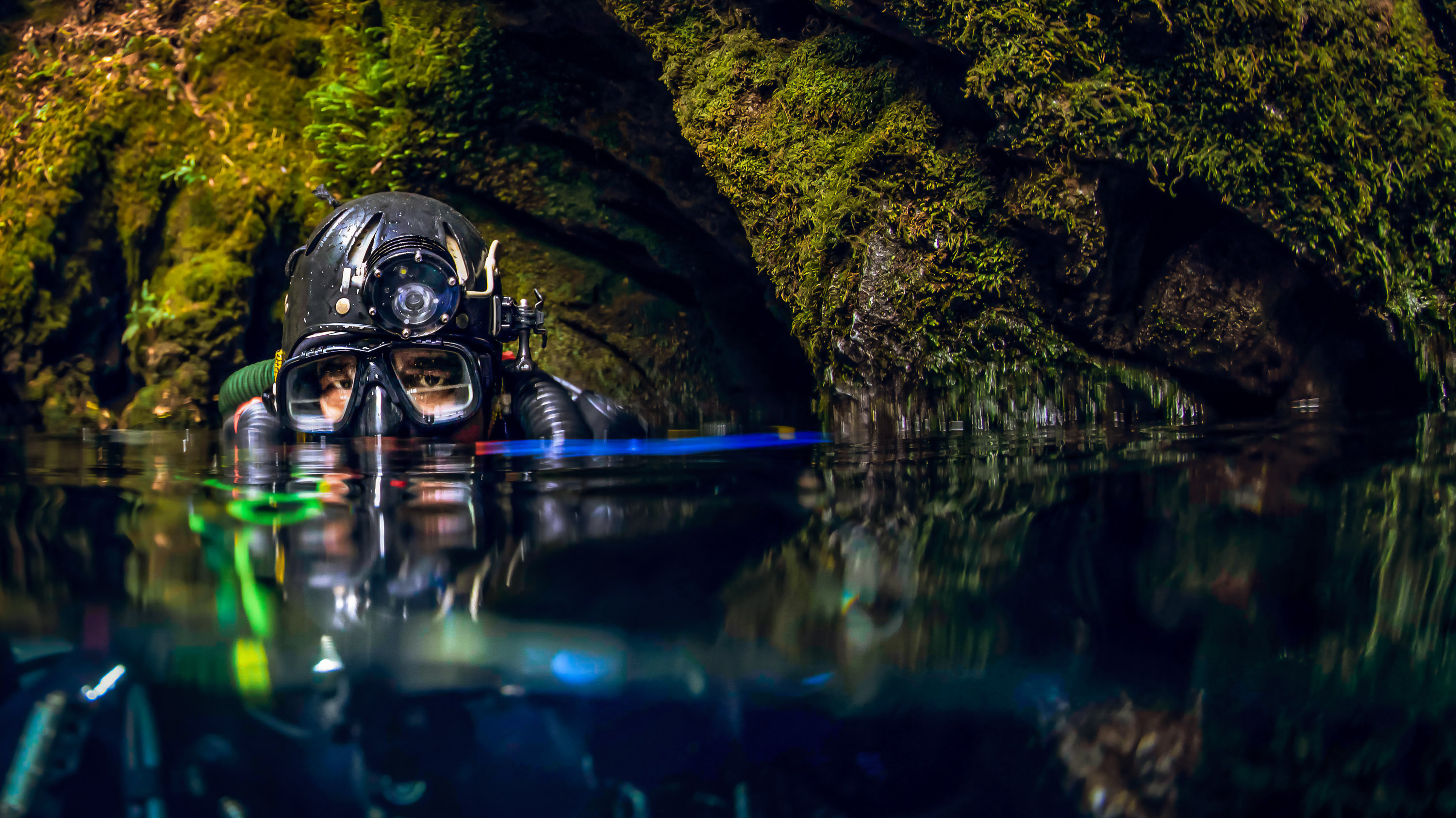 the top of a diver&#039;s head just above the waterline in a cave