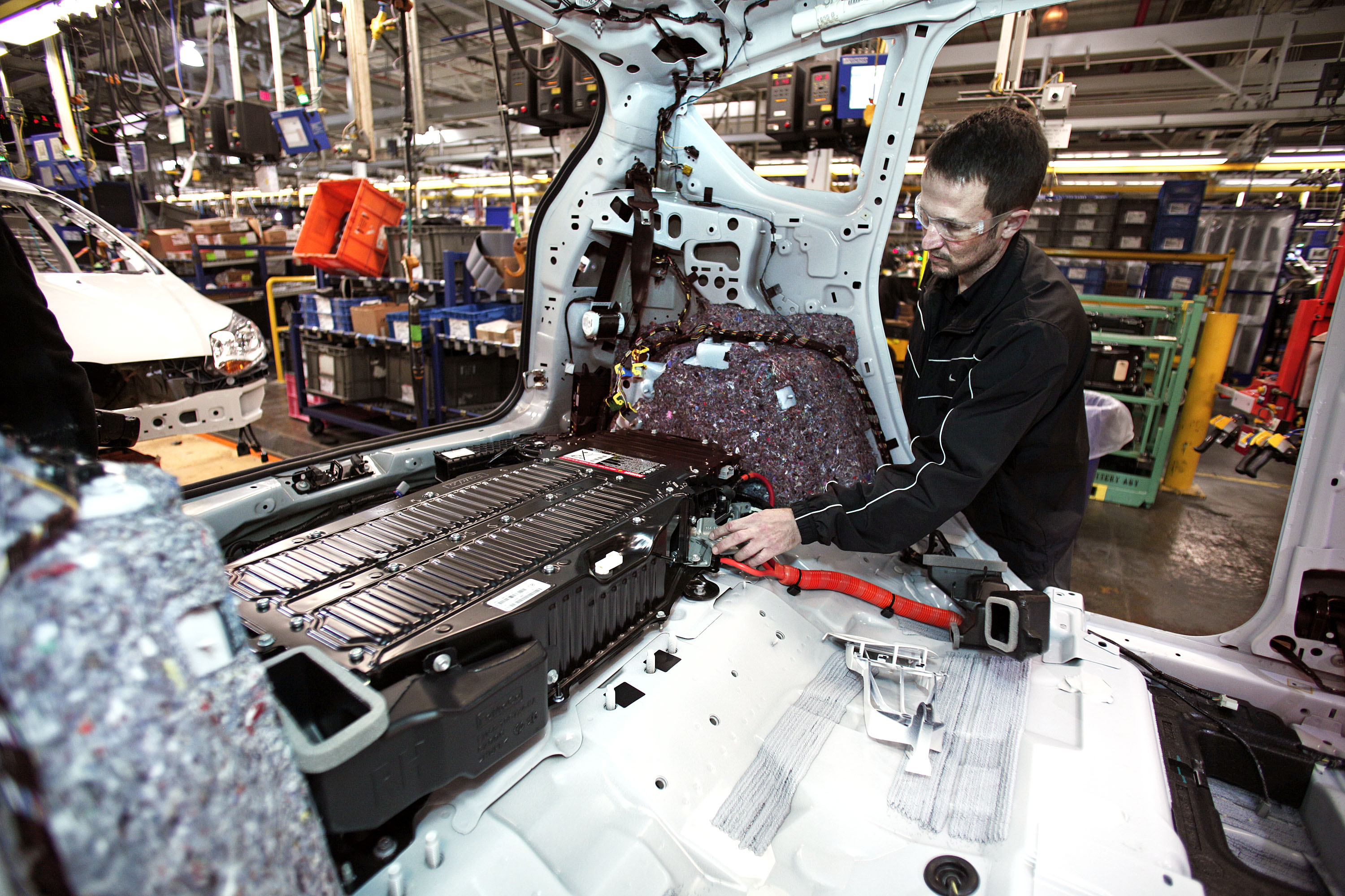 worker installs battery at Ford plant in Michigan