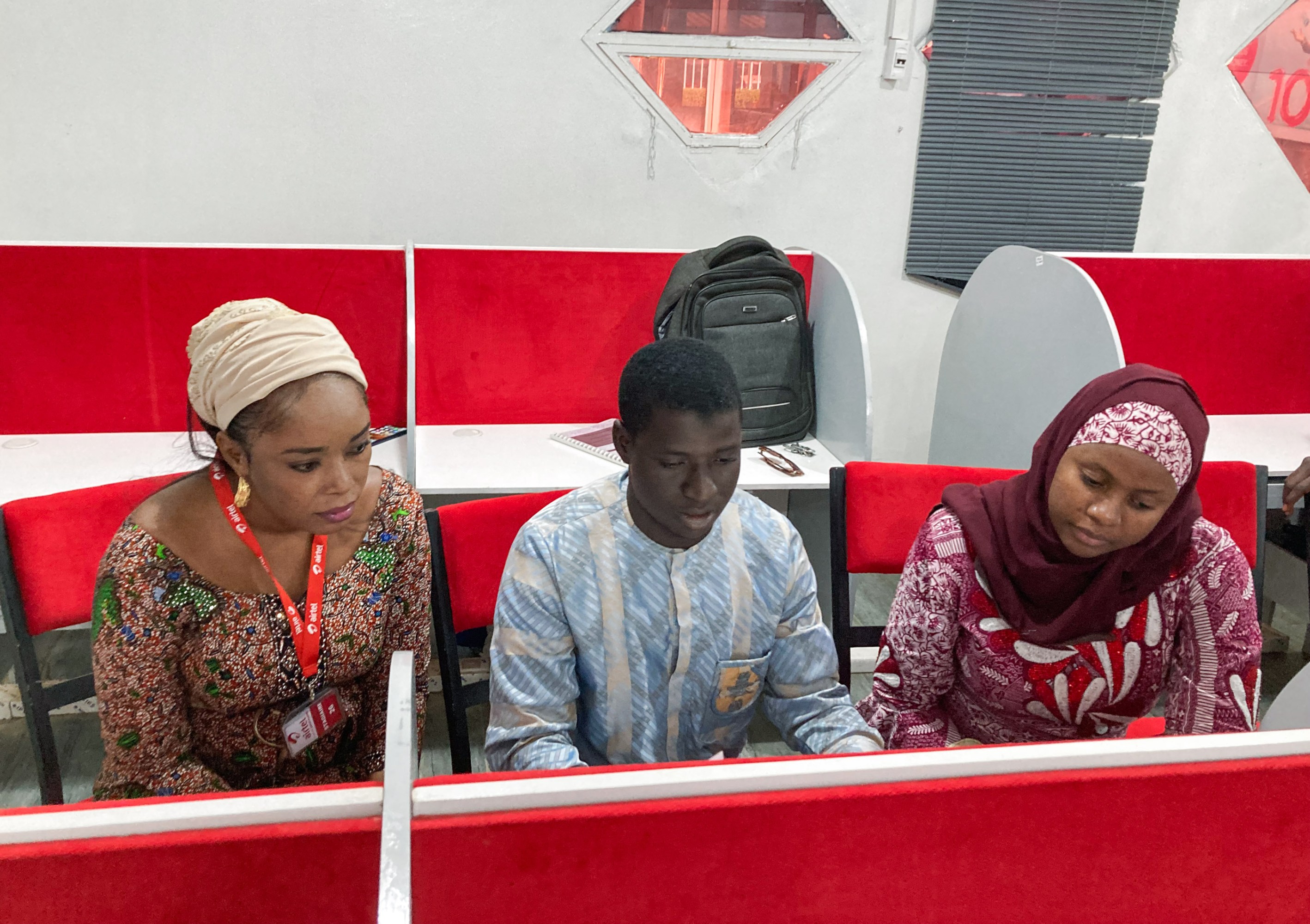 Garbal call center workers in red cubicles